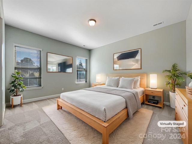 bedroom featuring light carpet and multiple windows