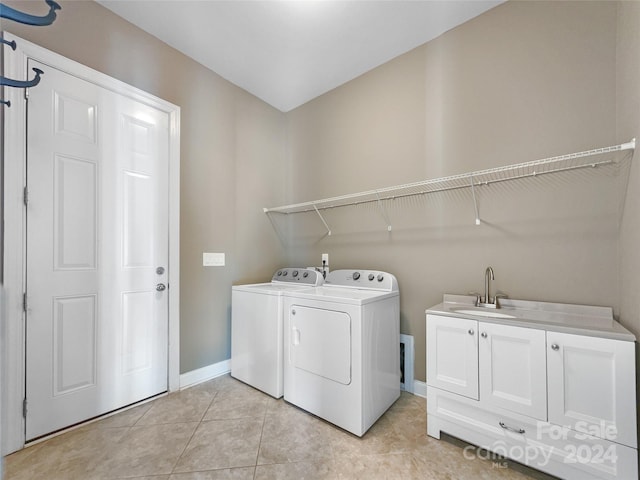 clothes washing area with light tile patterned floors, cabinets, sink, and washer and clothes dryer