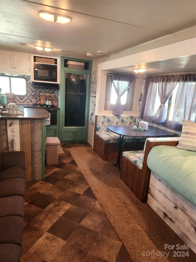 interior space with backsplash and black microwave