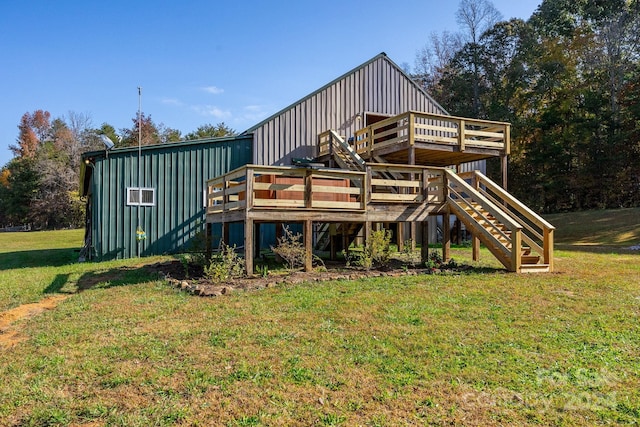 back of property with a lawn, stairs, board and batten siding, and a deck