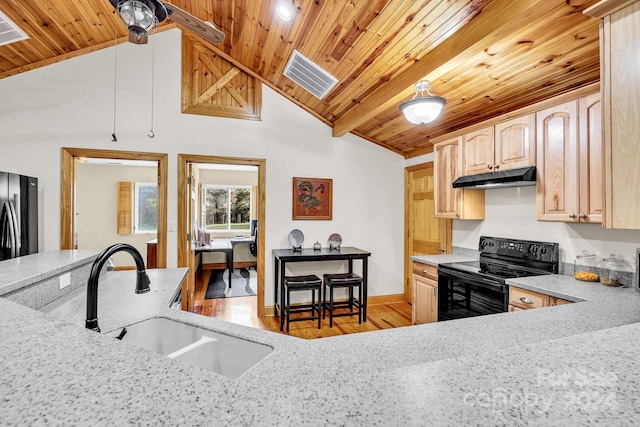 kitchen featuring vaulted ceiling with beams, light brown cabinets, black appliances, and light wood-type flooring