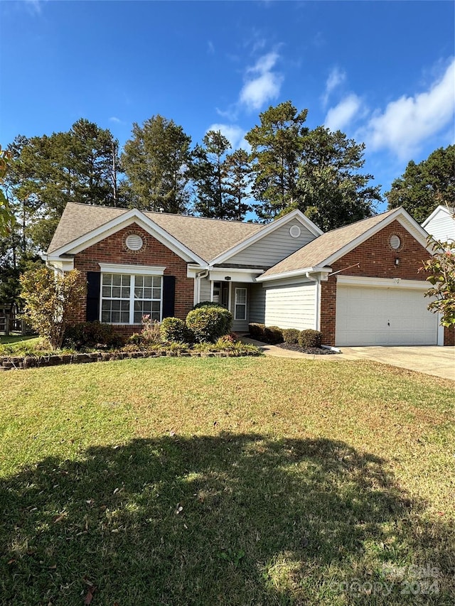 ranch-style house featuring a front lawn and a garage