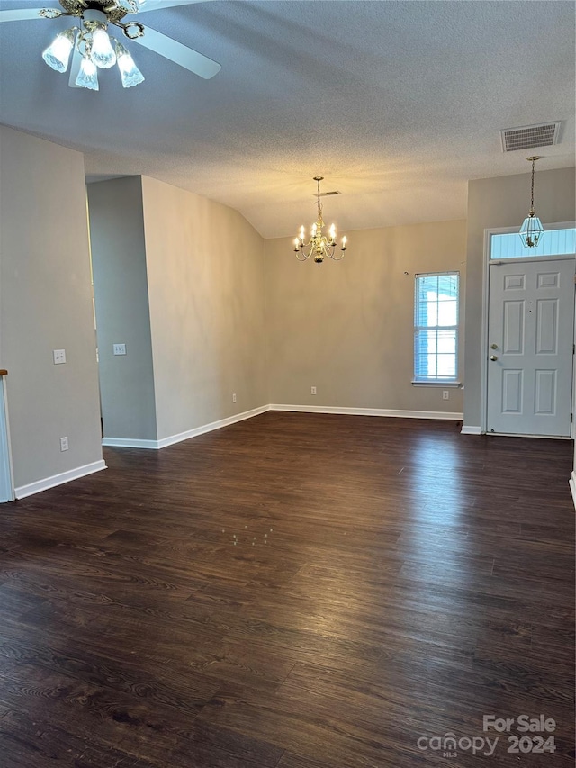 spare room with lofted ceiling, a textured ceiling, ceiling fan with notable chandelier, and dark hardwood / wood-style flooring