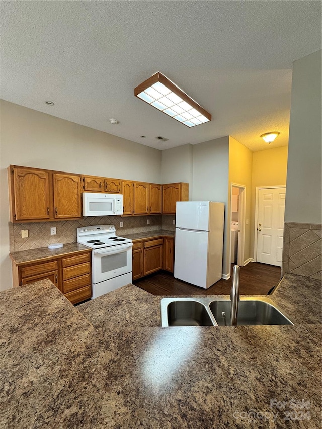 kitchen with sink, decorative backsplash, dark wood-type flooring, and white appliances