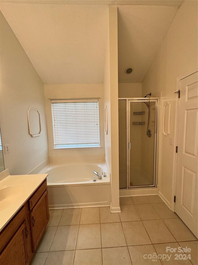 bathroom with vanity, separate shower and tub, and vaulted ceiling