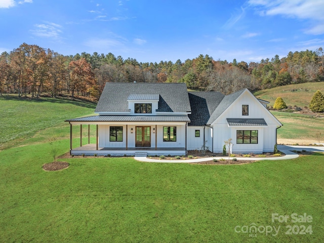 modern inspired farmhouse featuring a front lawn and covered porch