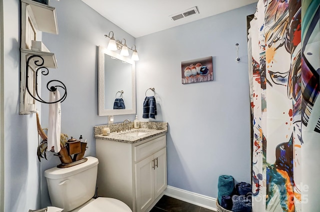 bathroom with vanity, visible vents, baseboards, and toilet