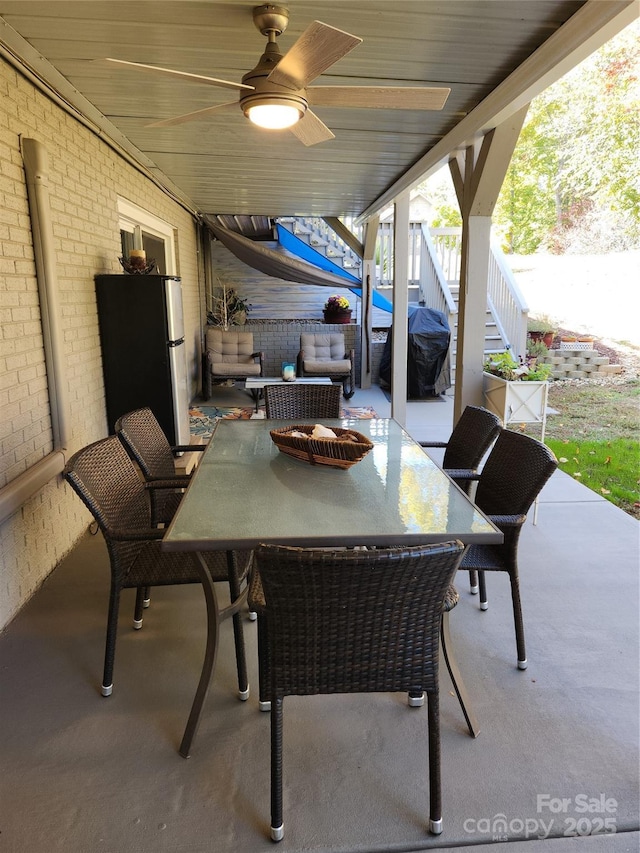 view of patio with grilling area, a ceiling fan, outdoor dining area, and stairs