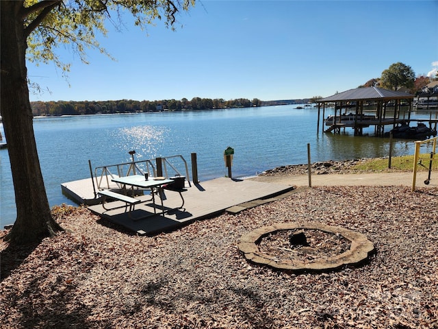 dock area with a water view and an outdoor fire pit