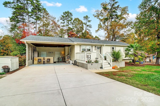 view of front facade with a carport, driveway, and a front lawn