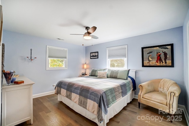 bedroom with visible vents, wood finished floors, baseboards, and ceiling fan