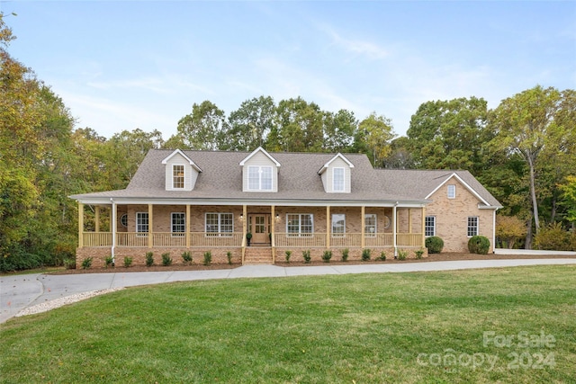 cape cod house featuring covered porch and a front yard