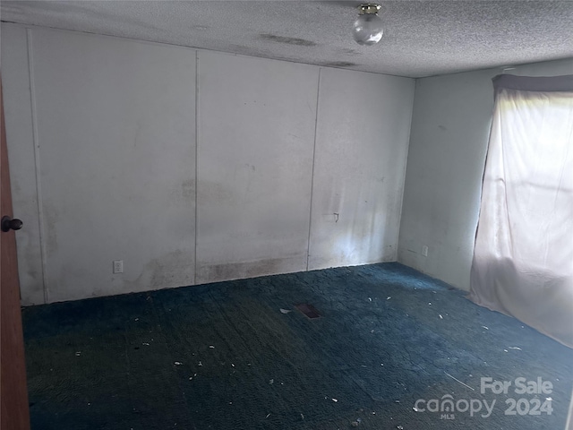 unfurnished room with a textured ceiling