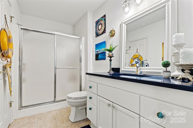 bathroom featuring tile patterned flooring, vanity, toilet, and a shower with shower door