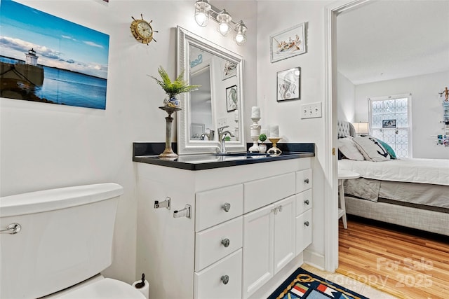 bathroom with hardwood / wood-style floors, vanity, and toilet