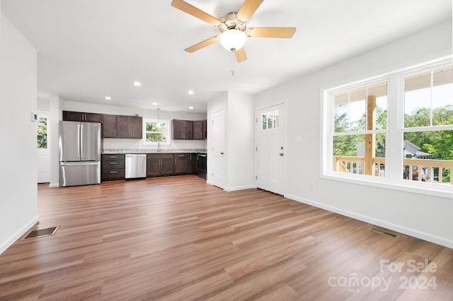 unfurnished living room featuring light hardwood / wood-style floors, ceiling fan, and sink