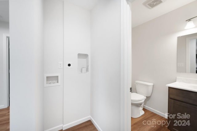 bathroom with hardwood / wood-style floors, vanity, and toilet