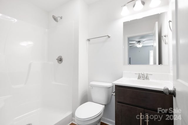 bathroom with vanity, ceiling fan, toilet, and walk in shower