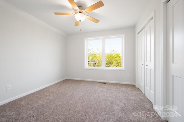 unfurnished bedroom with ceiling fan, a closet, and carpet floors