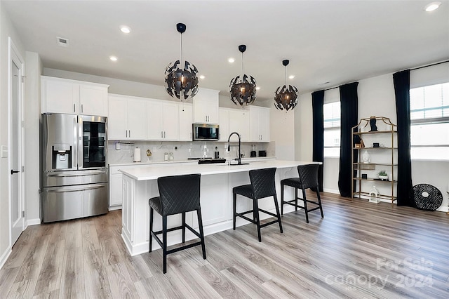 kitchen with plenty of natural light, white cabinetry, and appliances with stainless steel finishes