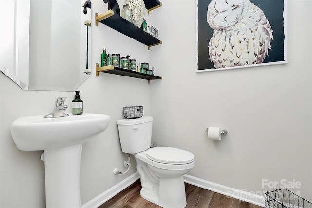 bathroom with hardwood / wood-style flooring, toilet, and sink