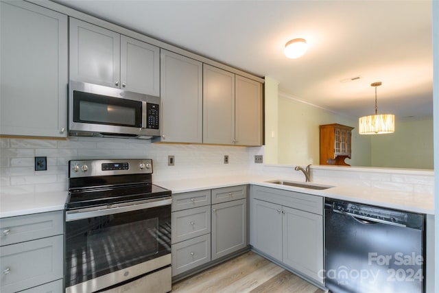 kitchen featuring gray cabinets, sink, appliances with stainless steel finishes, and backsplash