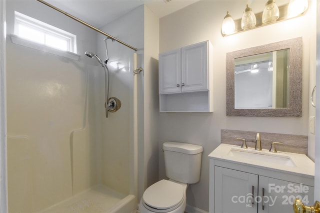 bathroom featuring vanity, toilet, and walk in shower