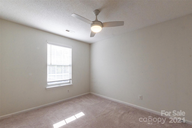 unfurnished room with light carpet, a textured ceiling, and ceiling fan