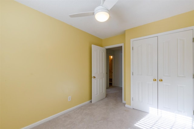 unfurnished bedroom featuring light colored carpet, a closet, and ceiling fan