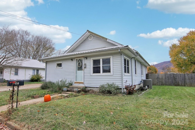 view of front facade with central AC and a front yard