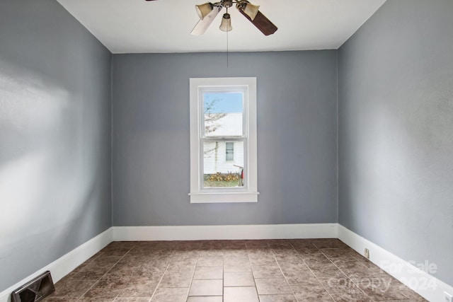 tiled spare room featuring ceiling fan