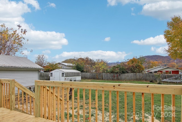 wooden terrace with a mountain view, a yard, and a shed