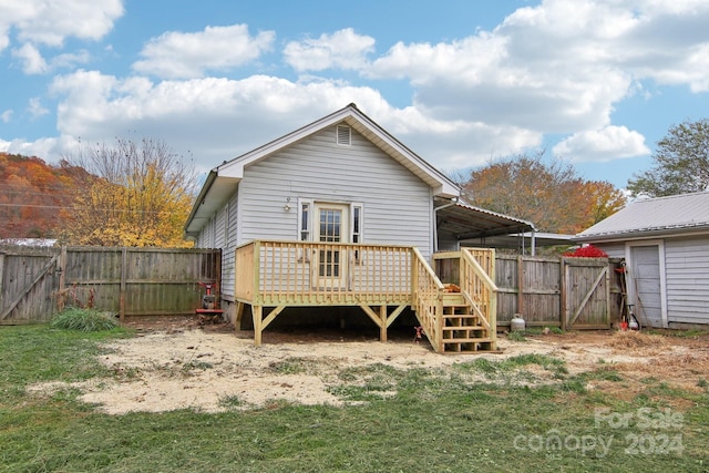 back of property with a deck and a lawn