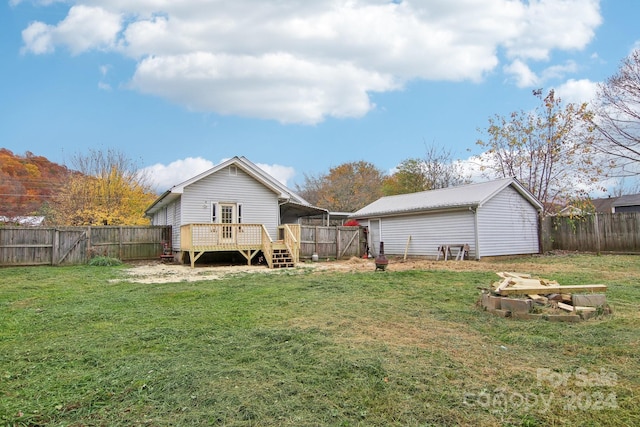 rear view of property featuring a yard and a wooden deck