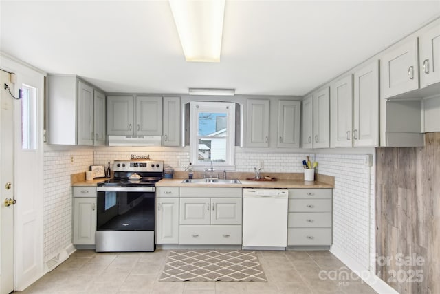 kitchen with sink, tasteful backsplash, stainless steel range with electric stovetop, light tile patterned floors, and white dishwasher