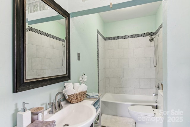 full bathroom featuring tiled shower / bath, sink, and toilet