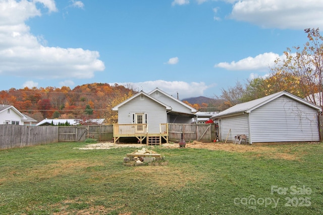 back of house with a lawn and a deck