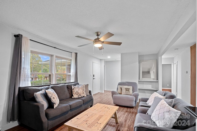 living room with a textured ceiling, hardwood / wood-style flooring, and ceiling fan