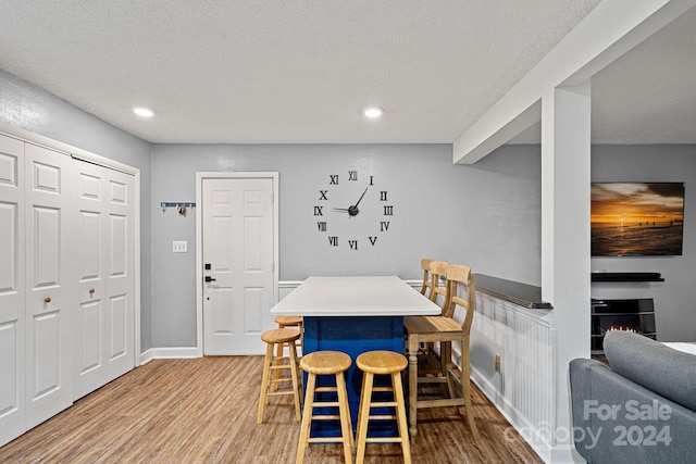 dining room featuring light hardwood / wood-style flooring and a textured ceiling