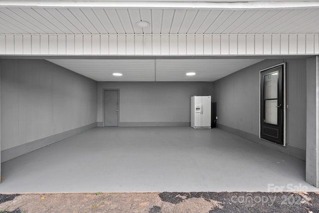 garage featuring white fridge with ice dispenser