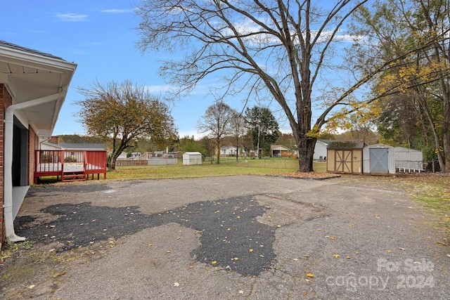 view of yard with a wooden deck and a storage shed