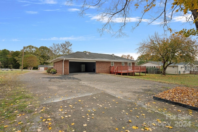 view of property exterior featuring a wooden deck and a garage