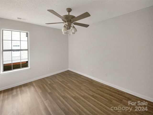 spare room featuring ceiling fan, a textured ceiling, and dark hardwood / wood-style flooring