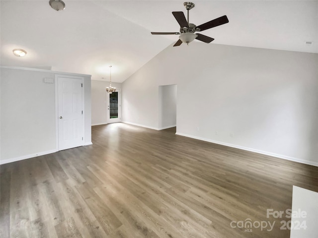 unfurnished living room featuring ceiling fan with notable chandelier, vaulted ceiling, and dark hardwood / wood-style floors