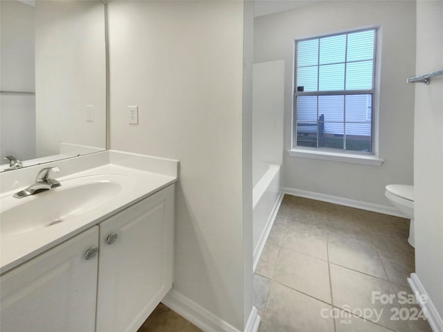 bathroom featuring toilet, a tub to relax in, vanity, and tile patterned floors