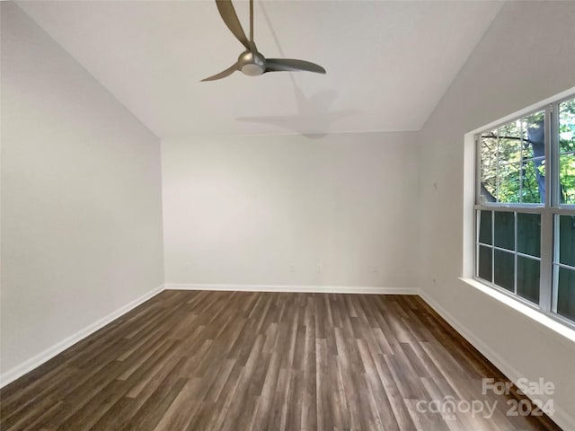 spare room with ceiling fan, dark wood-type flooring, and vaulted ceiling