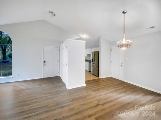 unfurnished living room with lofted ceiling, a notable chandelier, and hardwood / wood-style flooring