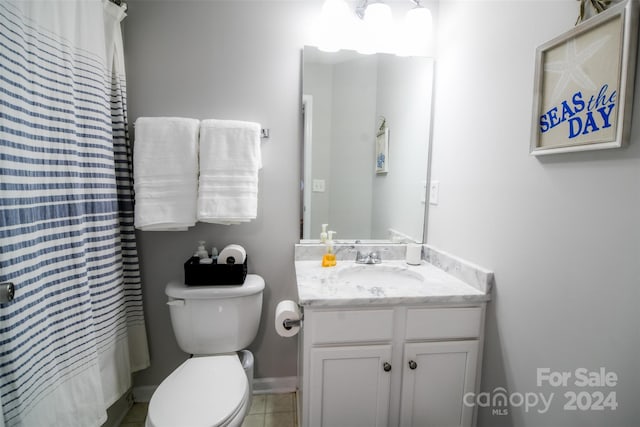 bathroom with tile patterned flooring, vanity, toilet, and walk in shower