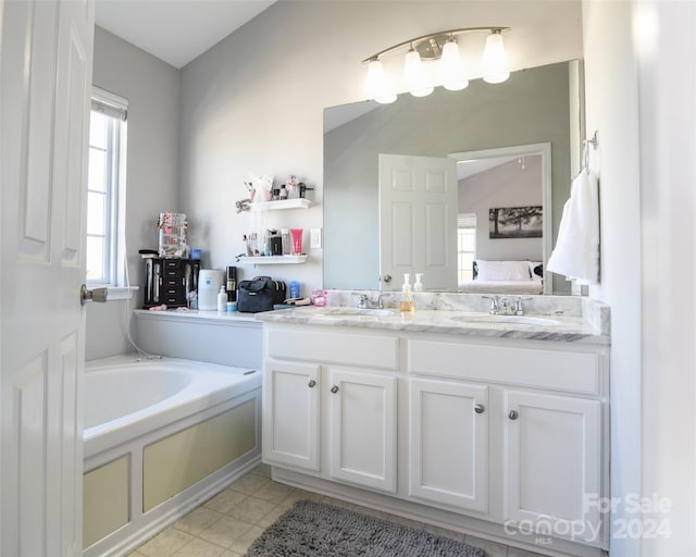 bathroom featuring tile patterned floors, a bathtub, and vanity