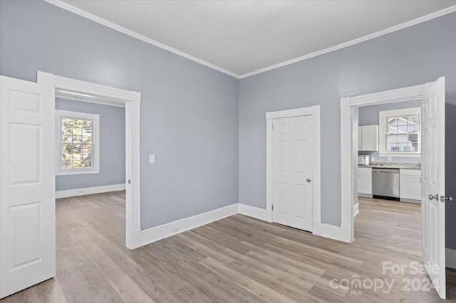 spare room featuring crown molding and light hardwood / wood-style flooring